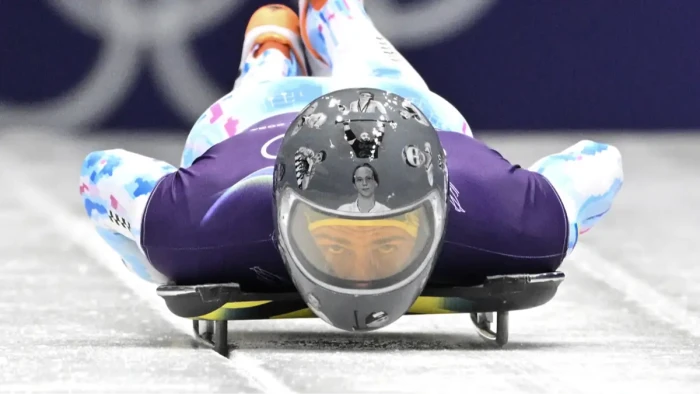 Ukrainian athlete Heraskevych with helmet attire, officials and support signs referencing disqualification