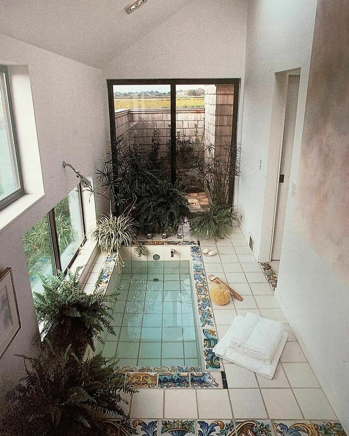 16. This Bathing Annex On The End Of A Modern Suburban Home Epitomizes Peace And Relaxation. A Sunken Tub Of Pure White Tile Is Trimmed With Hand-Painted Blue And Gold Tiles In A Room Equally Clean, Pure, And Neatly Bordered By Tile, Plants, And Windows.