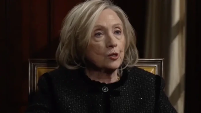 Hillary Clinton at a podium discusses allegations tied to Epstein files and accountability.