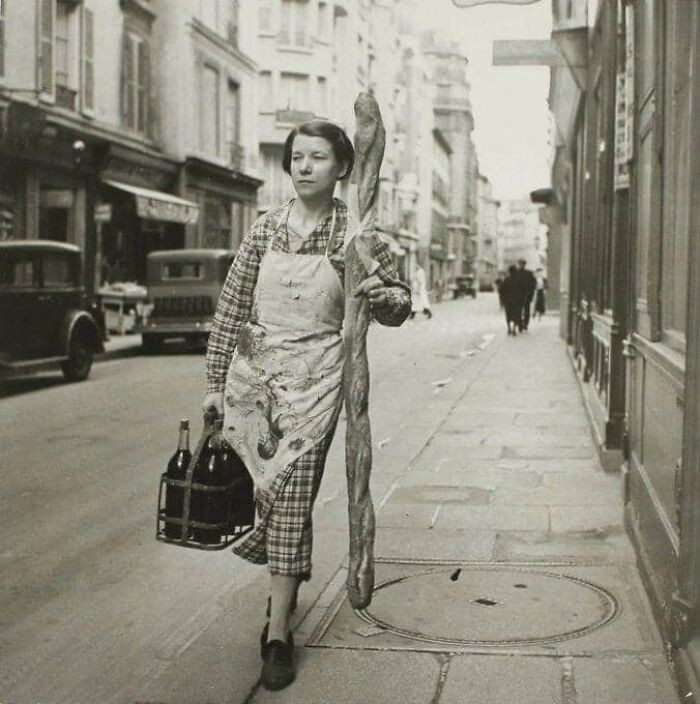 25. A woman on a mission with her baguette and six bottles of wine. (Paris, 1945 - by Branson Decou)