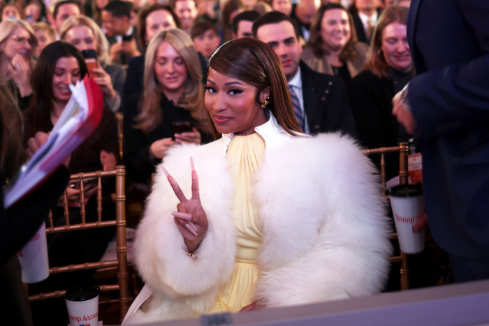 Nicki Minaj poses while holding or showing a Trump gold card.