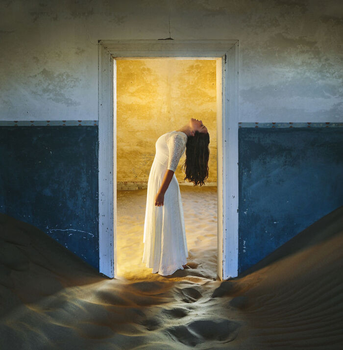 20. A calm pose in a white dress at the doorway while the desert quietly takes over inside
