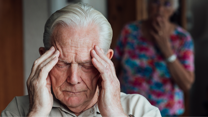 Caregiver adjusting home lighting for Alzheimer sundowning, creating calming environment.