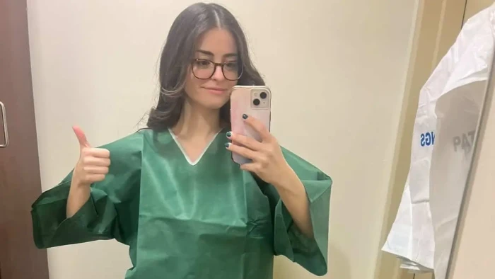 Woman holding medical documents, referencing unusual eye pain and cancer diagnosis