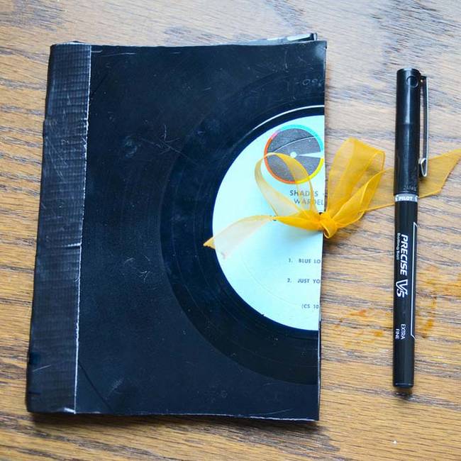 Create a unique notebook by repurposing an old record and duct tape.