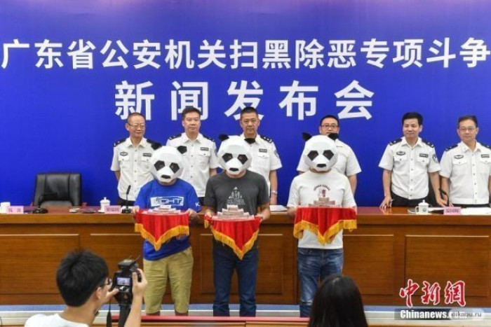 5. Officials, strange masked people, wads of money on trays