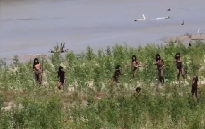 Explorer holds rare footage equipment during visit to isolated indigenous tribe