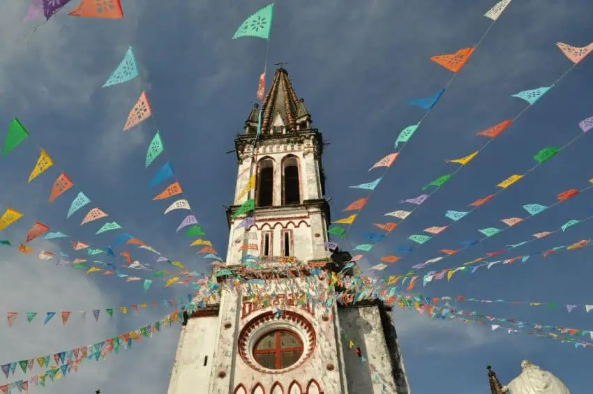 Traditional flags bedeck a cathedral in the Magical Town of Cuetzalan, Puebla.