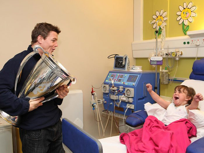 Irish rugby player Brian O'Driscoll is visiting a young girl in the hospital after winning the Heineken Cup. 