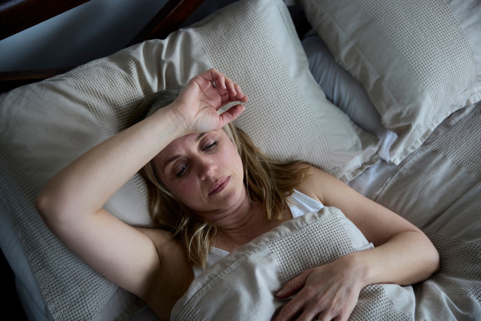 Person holding a pillow, highlighting early cancer detection and rising cases