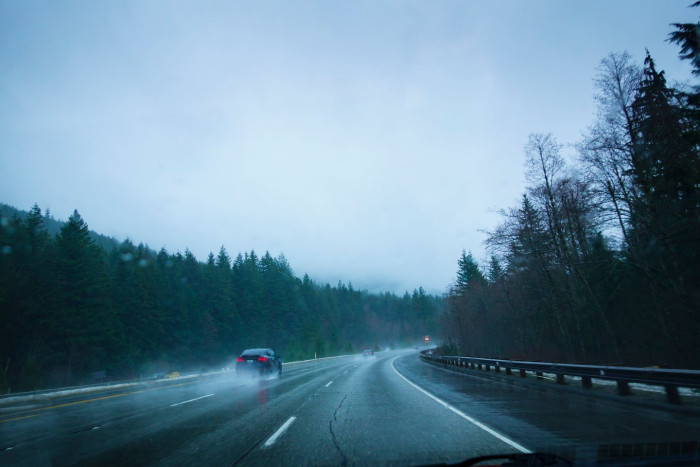 Foggy roadway with caution signs highlighting slick travel and aviation safety risks