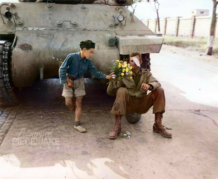 9. An Italian Boy Giving Flowers To An American Soldier Whose Tank Had Stopped On The Edge Of Rome, Italy In June 1944