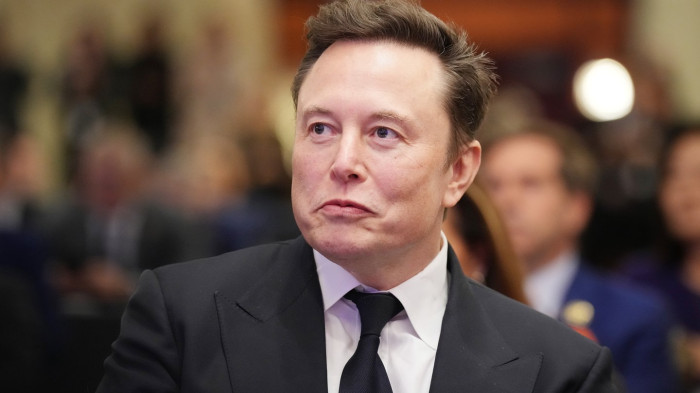 Elon Musk at a public event, referencing retirement planning and societal impacts.
