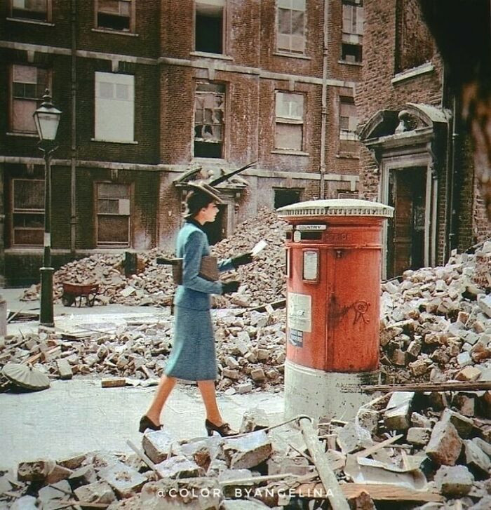 43. A Woman Posting A Letter In A Postbox Amongst Destroyed Buildings And Rubble Caused By German Air Raids During World War II. Photograph Taken In London, United Kingdom In 1940