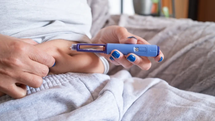 Person with sugary drinks and alcohol, highlighting hidden calories to avoid.