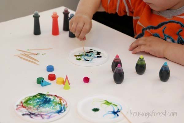 6. You can use plastic container lids, glue, and food coloring for a neat painting craft