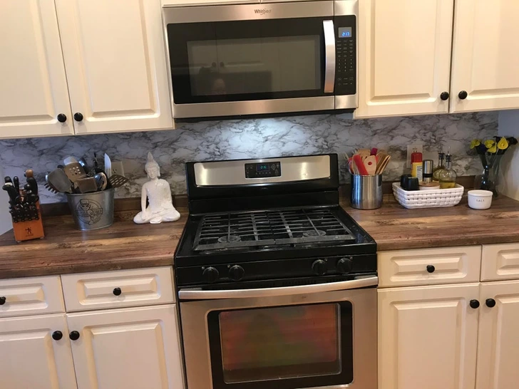 3. “I freshened up the kitchen for $16. I covered the backsplash and the counters in contact paper.”