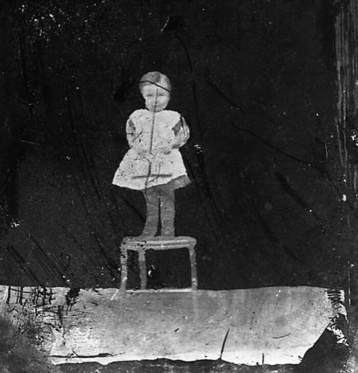 "A Child Standing On A Chair"