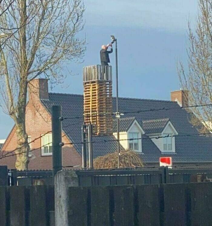 9. Just A Man On A Stack Of Pallets Raised By A Forklift Changing The Bulb On A Street Light