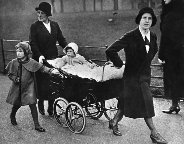 2. Walking alongside her nannies and a stroller holding her sister, Princess Margaret