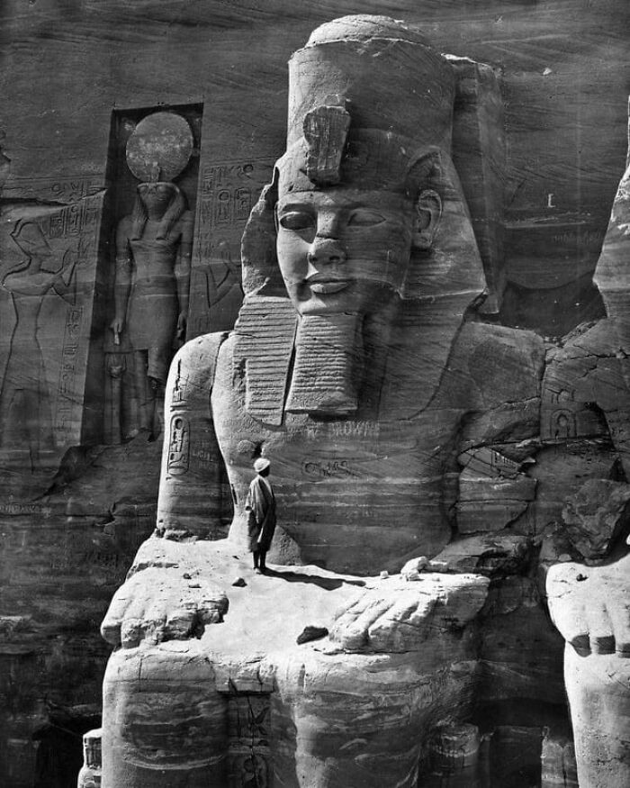 A man perched on the lap of a Ramesses statue, Egypt, 1856.