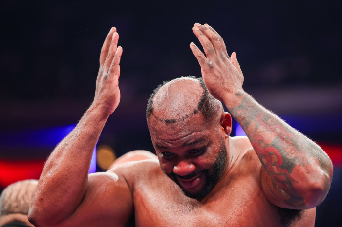 Boxer Jarrell Miller in the ring, reacting to a knocked-off hairpiece.