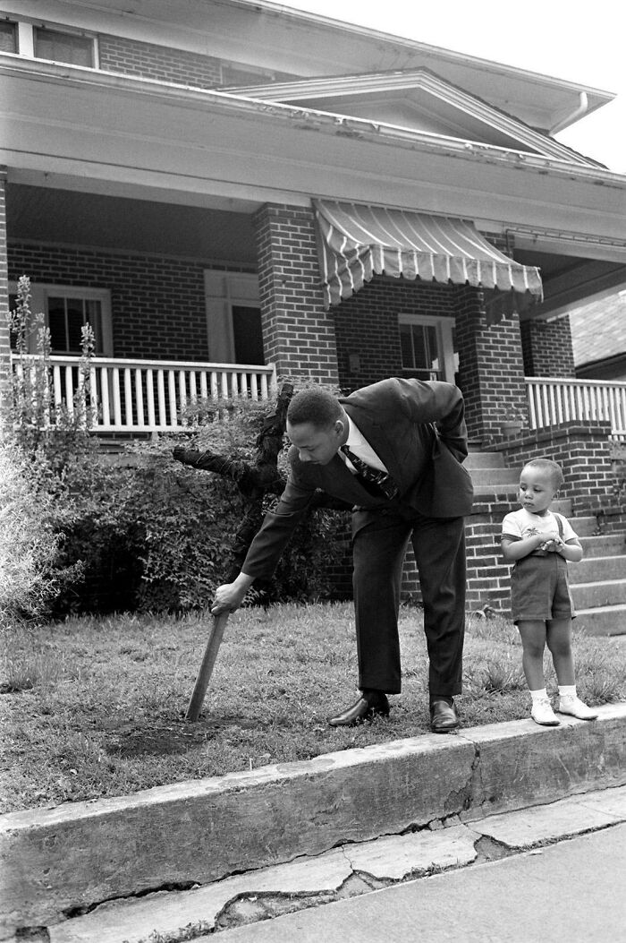 3. “Martin Luther King Jr. with his son, pulling up a burnt cross from the front lawn of his Atlanta home, April 1960.”