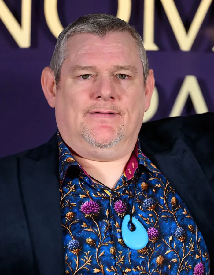 Alan Cummings speaks at an event, referencing Tourette’s awareness and outbursts