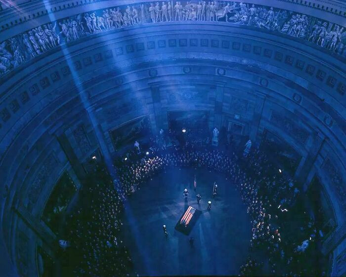 President John F. Kennedy’s flag-covered coffin rests in Washington, D.C., 1963, marking a moment of national mourning and quiet reflection.