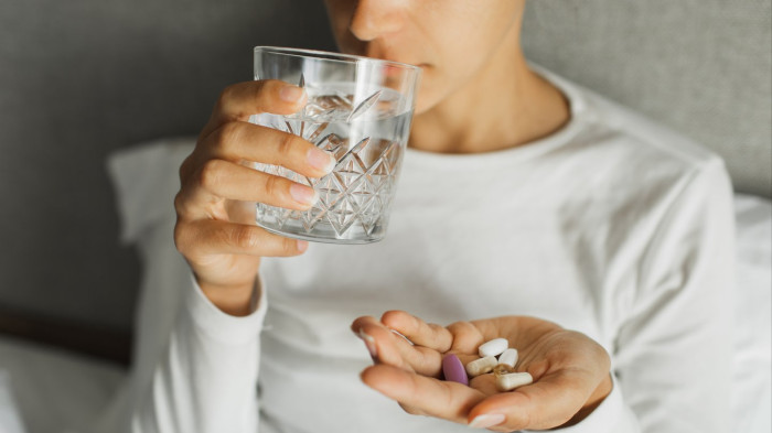 Close-up of person holding abdomen, nausea symptom linked to vitamin D supplements.