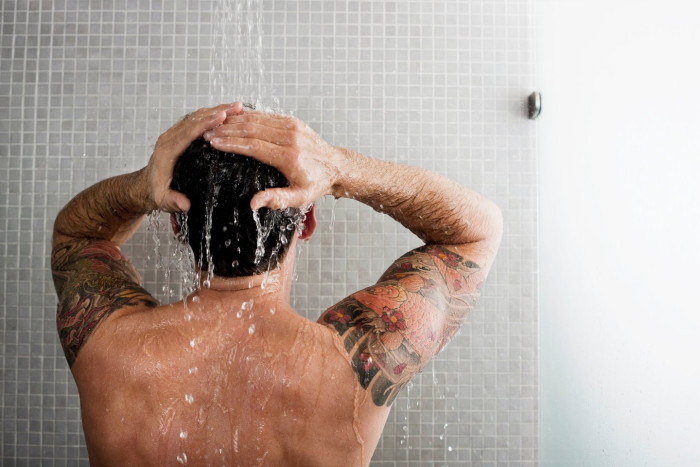 Person taking a daily shower, emphasizing balanced routine and skin care benefits