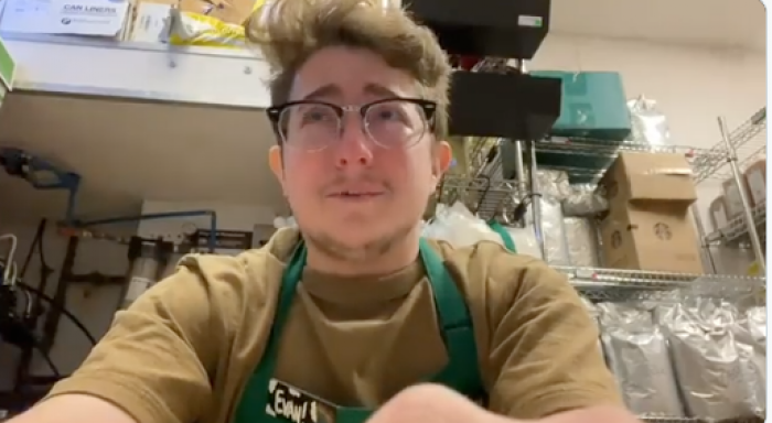 The Starbucks barista sits in his back room filled with supplies as he films this video.