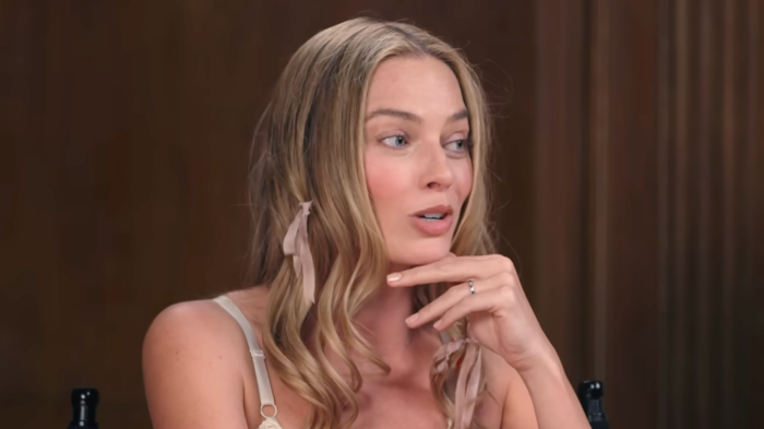 Margot Robbie at a public event, discussing industry pressure and worth tied to appearance