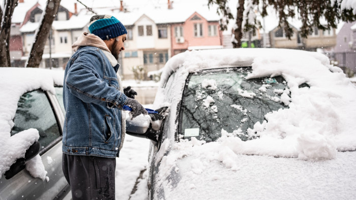 Lukewarm de-icing method showing safe windshield clearing, avoiding boiling water risks