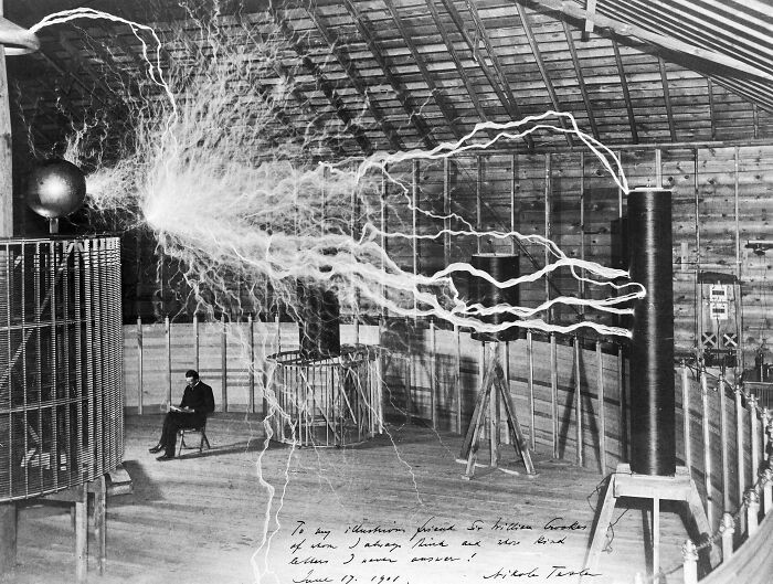 "Tesla Appears To Read Beneath 22-Foot Electrical Arcs In This Deliberately Staged 1899 Double Exposure"