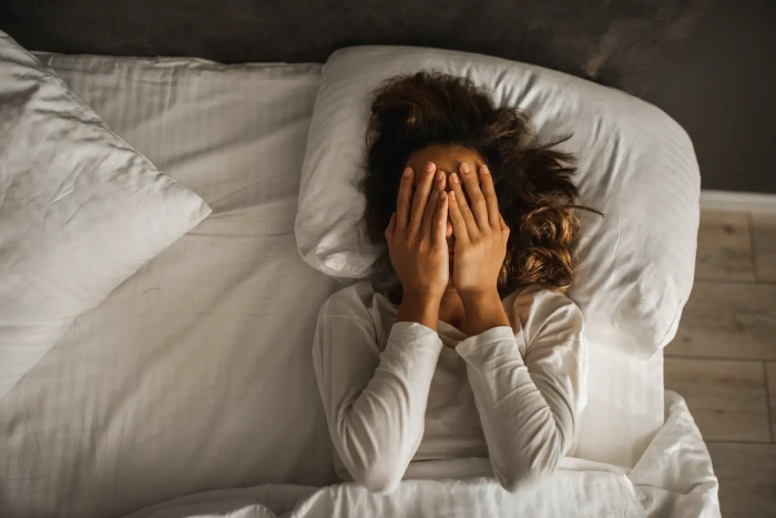 Bedroom thermostat and bedding setup showing balanced sleep temperature for heart health
