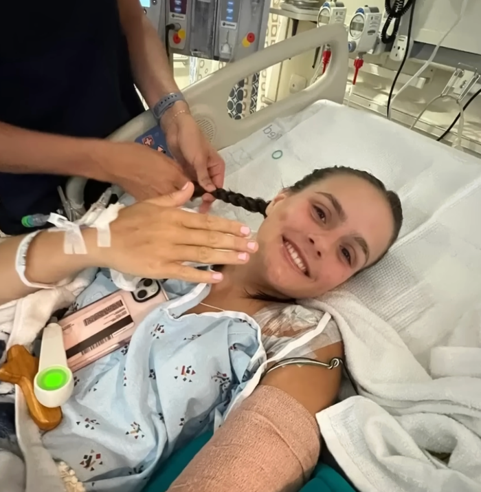 Teen survivor holds bandaged arm and leg after shark attack trauma
