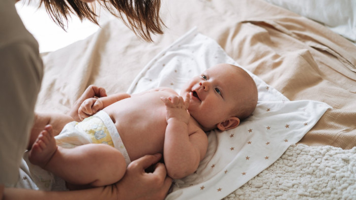 Parent holding baby, considering vintage baby name trends for 2024
