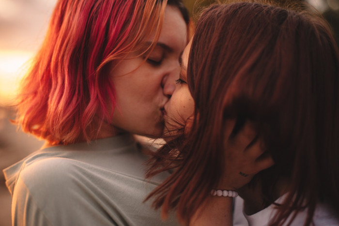 Close-up of two people kissing, one pulling back slightly, showing communication cues
