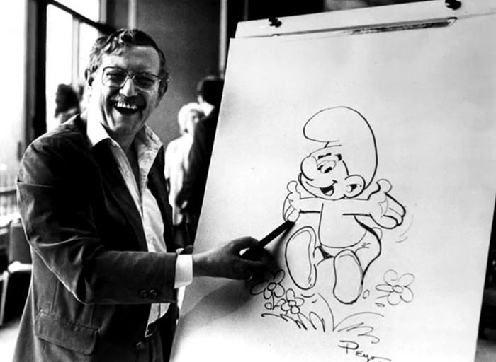 Pierre Culliford (Peyo), Creator Of The Smurfs, Presenting His Finished Drawing Of A Smurf At A Studio In Brussels, Belgium, 1983