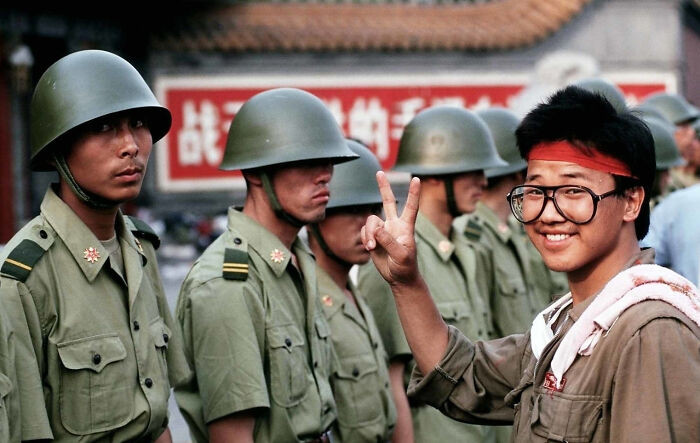"A Student Protester Flashes the Victory Sign in Front of Chinese PLA Soldiers at Tiananmen Square, June 1, 1989."