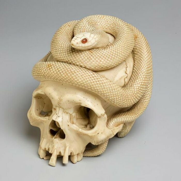 Carved ivory memento mori - skull, coiled snake, carnelian eyes. Edo Japan, 1860.