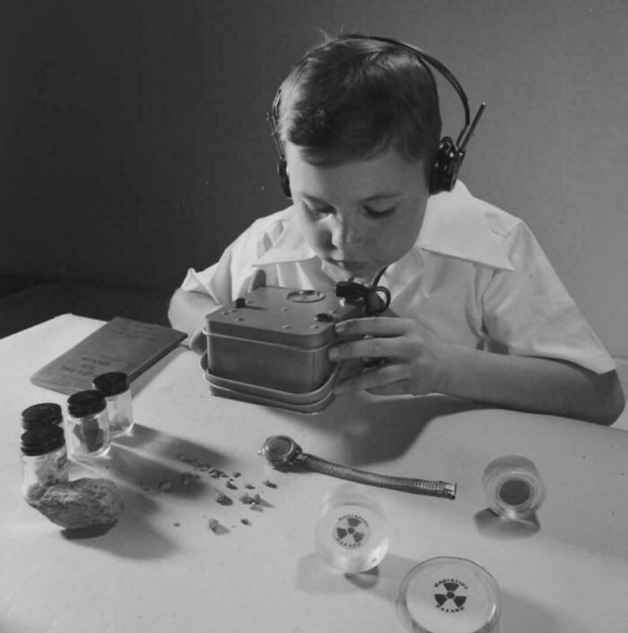 "A Young American Boy Examines Radioactive Samples From A Chemistry Set In 1950, Wearing Headphones Connected To A Geiger Counter Sensitive Enough To Detect Radiation From A Wristwatch"