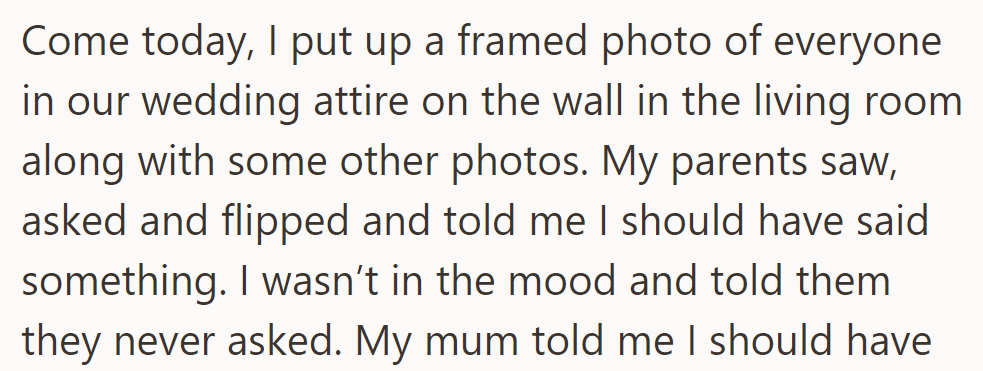 Hung up wedding photo; parents upset for not being told. OP tells them they never asked.