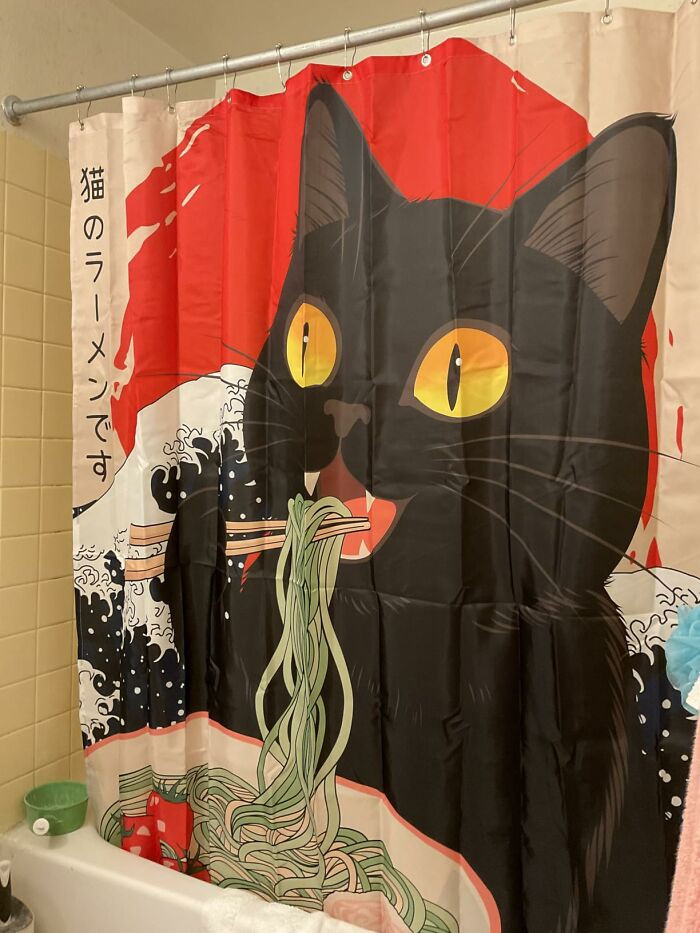 "This Shower Curtain Has An Hilarious Design Of A Demented Cat Rising Out Of The Sea And Slurping Ramen"