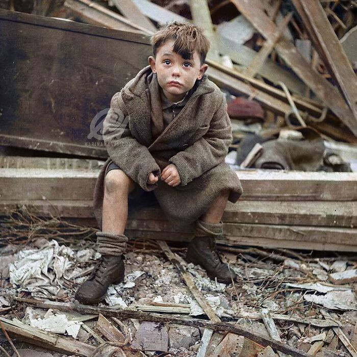 3. A Boy Sitting In The Wreckage Of A Building Shortly After A Bombing Raid Of London, England During World War 2. Photograph Was Taken In January 1945.