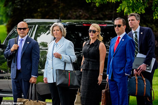 Walt Nauta, White House Chief of Staff Susie Wiles, White House Press Secretary Karoline Leavitt, Assistant to the President Sergio Gor, and another aide wait on the South Lawn as President Donald Trump prepares to board Marine One.