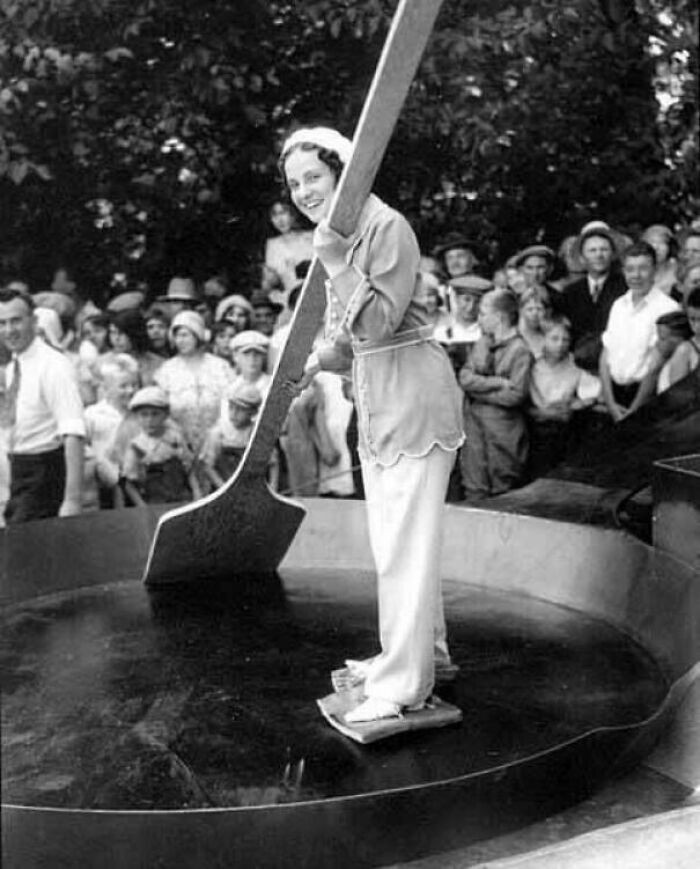 "Woman With Slabs Of Bacon Tied To Her Feet Standing In A Giant Skillet Holding An Enormous Wooden Spatula, Chehalis, Washington 1929"