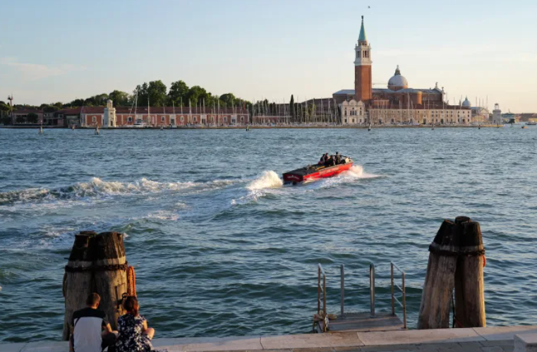 Guests arrive at San Giorgio Maggiore by boat for the wedding.